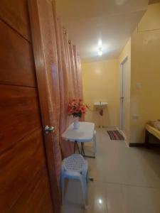 a room with a table and a chair and a door at CheRi Backpackers Hostel in Moalboal +55 photos