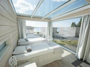 two beds in a room with a large window at Seaside Glass Villas in Kemi