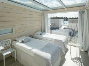 two beds in a room with a window at Seaside Glass Villas in Kemi