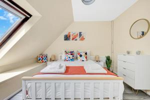 a white attic bedroom with a bed and a window at Charming 3 Bedroom House near Canary Wharf in London