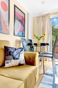 ein Wohnzimmer mit einem Sofa und einem Tisch mit einem Laptop in der Unterkunft Charming 3 Bedroom House near Canary Wharf in London