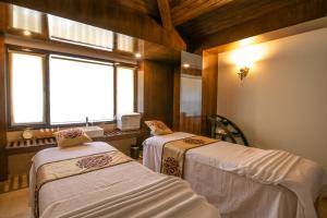 two beds in a room with a window at Rock Manali by Vivaan in Manāli +120 photos
