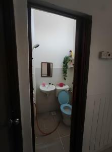 a bathroom with a blue toilet and a sink at Rumah teres 2 tingkat & 3 bilik in Pasir Gudang