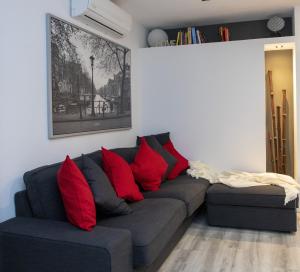 ein Wohnzimmer mit einem Sofa und roten Kissen in der Unterkunft Apartamento Virgen del Remedio in Novelda