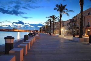 una calle de la ciudad con palmeras y un canal en Victory Suite 31, en Brindisi