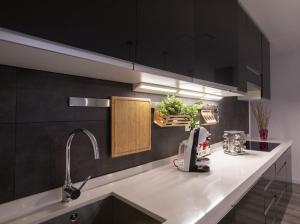 eine Küche mit schwarzen Schränken und einer Theke mit einer Spüle in der Unterkunft Apartamento Virgen del Remedio in Novelda + 13 Fotos