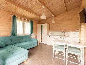 - un salon avec un canapé bleu et une table dans l'établissement Domki Siódme Niebo, à Stegna
