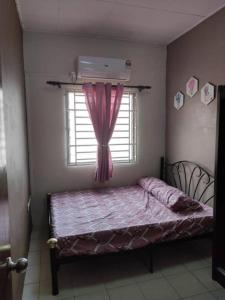 a bedroom with a bed and a window with a red curtain at Rumah teres 2 tingkat & 3 bilik in Pasir Gudang