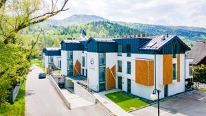 a row of houses with mountains in the background at Brylant Szczyrku - Apartament Kalinowa 23 blisko centrum - Dream Apart in Szczyrk