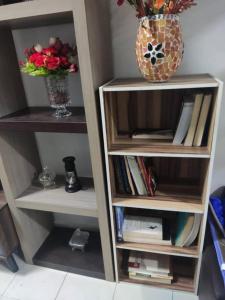 ein Bücherregal mit einer Vase darüber in der Unterkunft Rumah teres 2 tingkat & 3 bilik in Pasir Gudang