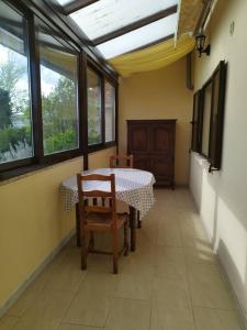 - une salle à manger avec une table, des chaises et des fenêtres dans l'établissement L'hirondelle du faubourg, à Bar-sur-Aube