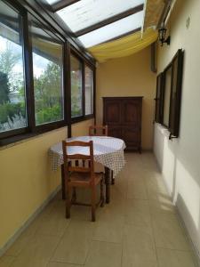a dining room with a table and chairs and windows at L'hirondelle du faubourg in Bar-sur-Aube