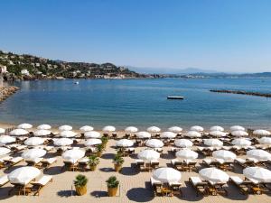 a group of umbrellas and chairs on a beach at Château de Théoule Hôtel & Spa in Théoule-sur-Mer