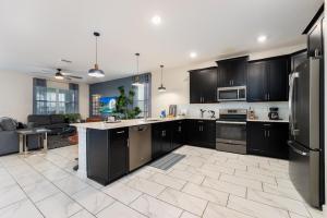 uma grande cozinha com armários e electrodomésticos pretos em Spacious 8BR Villa by Disney World w Private Pool em Kissimmee