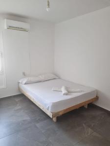 een bed in een kamer met een witte muur bij בובה של דירה in Eilat