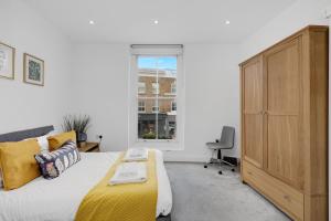 a bedroom with a bed and a dresser and a window at New 1 Bedroom flat right on Broadway Market! in London