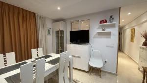 a kitchen and dining room with a table and a television at Benidorm Beach in Benidorm