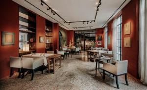 a restaurant with red walls and tables and chairs at Hotel PURS in Andernach