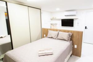 a small bedroom with a bed and a tv at Unity Beira Mar de João Pessoa by Carpediem in Penha +32 photos