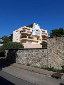 a building sitting on top of a stone wall at Coralline, Appartement lumineux à 2 pas de la mer. in Wimereux
