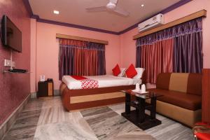 pokój hotelowy z łóżkiem i kanapą w obiekcie OYO Flagship Rainbow Guest House w mieście Jādabpur