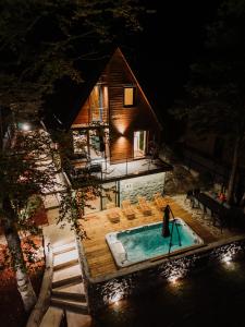 basen z krzesłami i dom w nocy w obiekcie The Magic Forest - Holiday Home & Spa Zone Platak w mieście Soboli