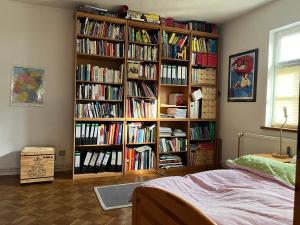 une étagère remplie de livres dans une chambre dans l'établissement Haus Winterlinde mit herrlich verzaubertem StaudenGarten, 