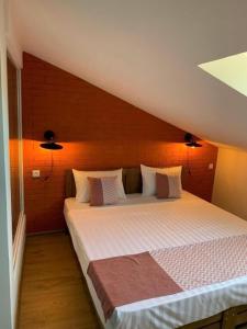 a bedroom with a large bed with an orange wall at Tbil Inn Hotel in Tbilisi City