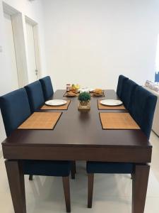 une table en bois entourée de quatre chaises bleues dans l'établissement Cozy apartment Battaramulla, à Colombo