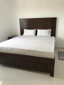 - un grand lit avec une tête de lit en bois dans une chambre dans l'établissement Cozy apartment Battaramulla, à Colombo