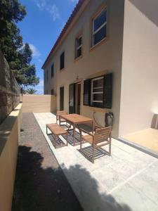 un tavolo da picnic e 2 panche di fronte a un edificio di Casa das Lombas a Vila Baleira