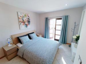 Un dormitorio con una cama azul y una ventana en Idaira Paradise, en Playa Paraiso