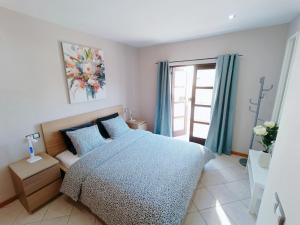 a bedroom with a blue bed and a window at Idaira Paradise in Playa Paraiso +18 photos