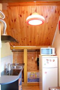 a kitchen with a sink and a microwave and a stove at Singing sands Apartment in Saulkrasti in Saulkrasti