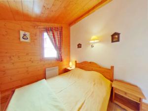 1 dormitorio con 1 cama en una cabaña de madera en Appartement Villard-sur-Doron, 4 pièces, 10 personnes - FR-1-594-198 en Villard-sur-Doron