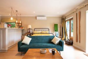 un soggiorno con divano verde e letto di Granby Estate The Old Pool House a Bradford on Avon