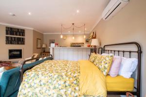 Schlafzimmer mit einem Bett mit gelber Bettwäsche und Kissen in der Unterkunft Granby Estate The Old Pool House in Bradford on Avon