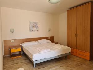 Schlafzimmer mit einem Bett und einem Holzschrank in der Unterkunft Hotel Florida in Limone sul Garda