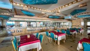 ein Restaurant mit Tischen und Stühlen und einer Theke in der Unterkunft Daima Biz Hotel - Dolusu Aquapark Access in Kemer