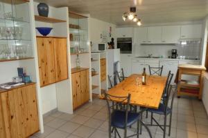 una cocina con mesa de madera y sillas. en Zeewind II 278, en Bredene