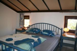 a bedroom with a bed with blue pillows on it at Zeewind II 278 in Bredene