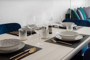 a table with plates and wine glasses on it at LA apartments in Maribor