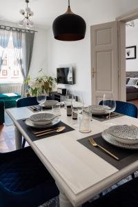 a dining room table with plates and wine glasses at LA apartments in Maribor