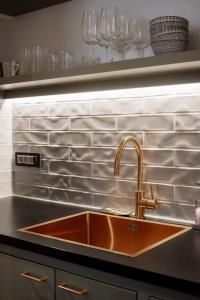 a kitchen with a sink and a counter with wine glasses at LA apartments in Maribor