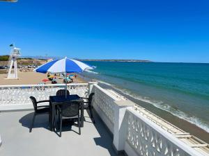 una mesa con sillas y una sombrilla en la playa en Pinet Playa, en Alicante