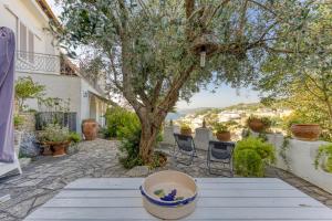 un patio con una mesa con un árbol y sillas en Villa Blu La Cambusa en Castro di Lecce