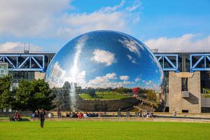 a person walking in front of a large ball in a field at Studio number 7 in Pantin