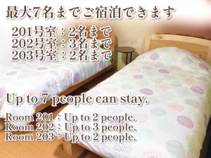 a poster of a bedroom with a bed and a sign at ゲストハウスわかばGuestHouse Wakaba in Iwami in Iwamicho