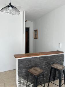 una cocina con barra de ladrillo y 2 taburetes en Villa 47 en Biguglia