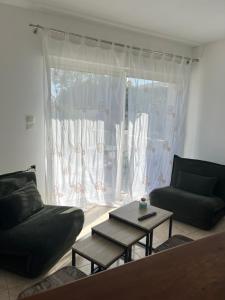 sala de estar con sofá, mesa y ventana en Villa 47 en Biguglia